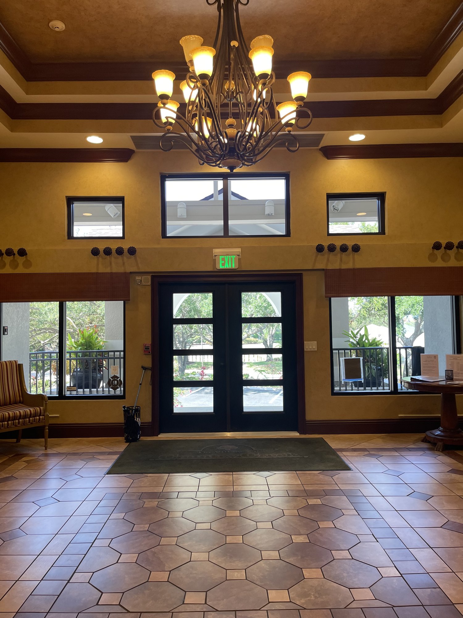VCC clubhouse lobby before renovation with chandelier and front entrance doors