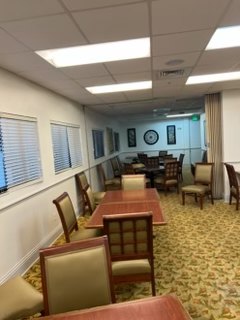 Downstairs activity room before renovation with tables and chairs